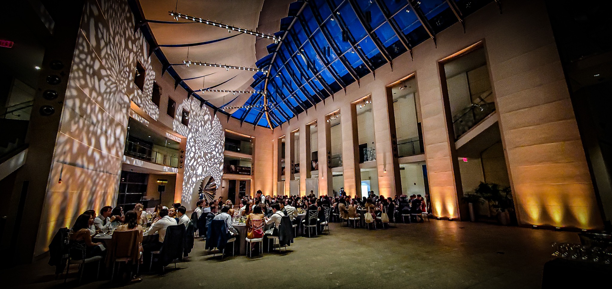A wedding reception transformed with warm uplighting and projected architectural patterns